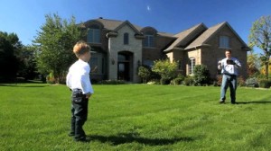 stock-footage-a-father-and-young-son-play-catch-in-front-of-their-luxury-home